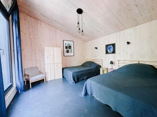 a bedroom with a bed and a chair in a room at Super nice holiday home by the lake in Templin