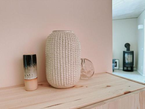 a white vase sitting on top of a wooden table at Super nice holiday home by the lake in Templin