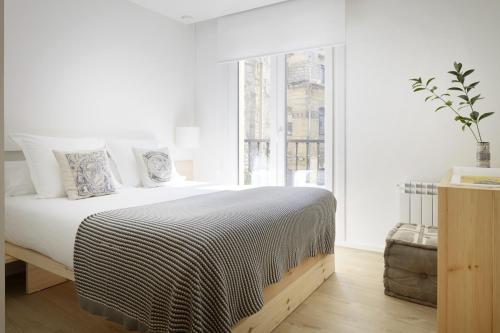 biała sypialnia z dużym łóżkiem i oknem w obiekcie Santa Maria by FeelFree Rentals w mieście San Sebastián