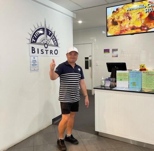 a man standing in front of a bistro counter at Time and Tide Hotel Motel in Collaroy
