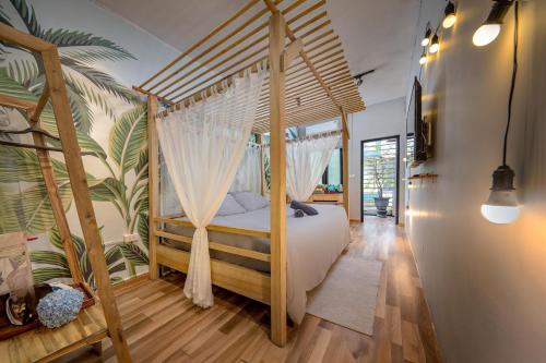 a bedroom with a canopy bed with white drapes at Trinh's House - Hang Vai in Hanoi