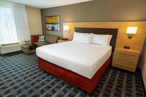 a hotel room with a large bed and a chair at TownePlace Suites Irvine Lake Forest in Lake Forest