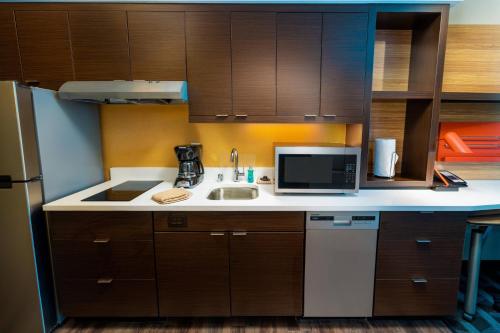 a kitchen with a sink and a microwave at TownePlace Suites Irvine Lake Forest in Lake Forest