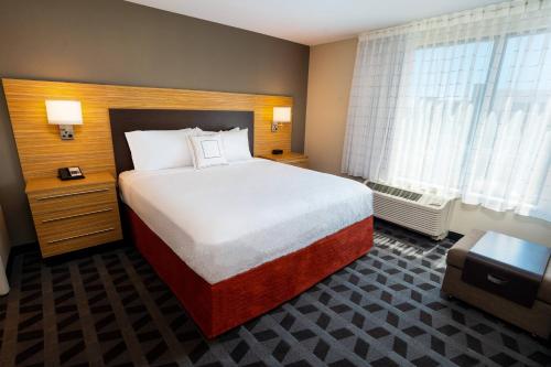 a hotel room with a large bed and a window at TownePlace Suites Irvine Lake Forest in Lake Forest