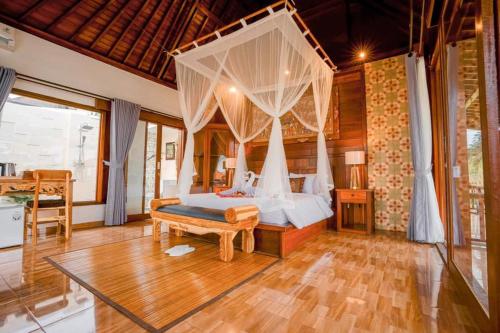 1 dormitorio con cama con dosel y suelo de madera en Umakelod Sebatu Villas, en Ubud