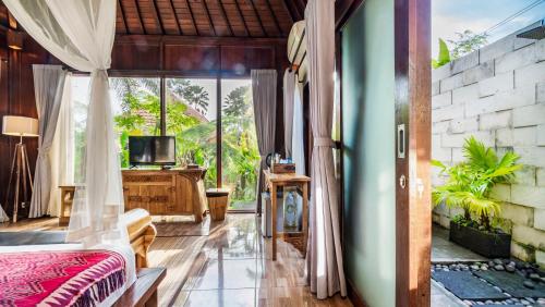 a bedroom with a bed and a tv in a room at Umakelod Sebatu Villas in Ubud