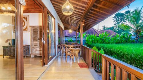 an open porch with a table and chairs on it at Umakelod Sebatu Villas in Ubud