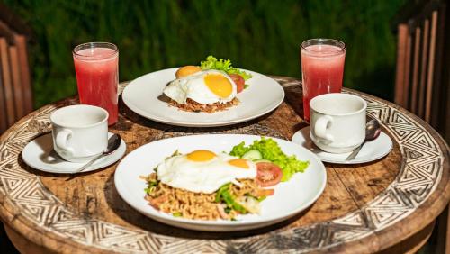 a table with plates of food and drinks on it at Umakelod Sebatu Villas in Ubud