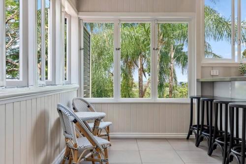 a screened in porch with chairs and windows at Poppy's Place! 4Bed/1Bath/2Car/Views/House ~Bardon in Brisbane