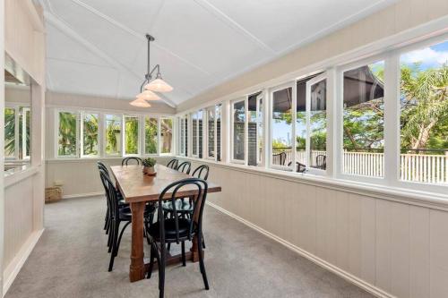 a dining room with a table and chairs and windows at Poppy's Place! 4Bed/1Bath/2Car/Views/House ~Bardon in Brisbane