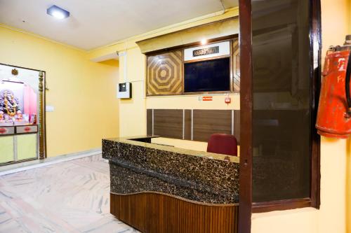 una habitación de hotel con un bar con TV en Hotel Nimisha Jail Rd en Sītāpur