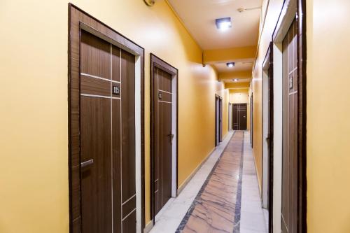 un pasillo con puertas marrones y paredes amarillas en Hotel Nimisha Jail Rd en Sītāpur