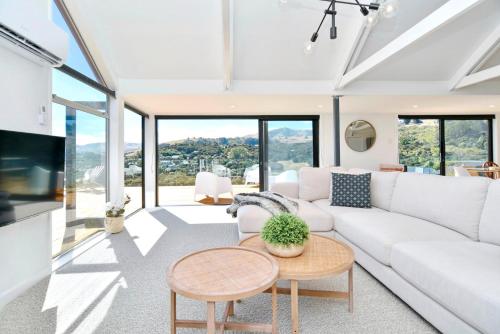 a living room with a white couch and a table at Akaroa Harbour View - Christchurch Holiday Homes in Akaroa