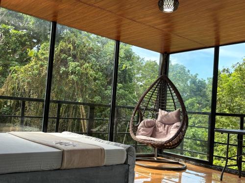a room with a hammock in front of a large window at Kembali coast resort A-house style in Caliclic
