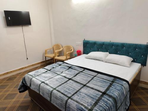 Shree Sukhdham Hotel tesisinde bir odada yatak veya yataklar