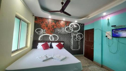 Schlafzimmer mit einem Bett mit Dusche und einem TV in der Unterkunft Hotel J K Inn Puri Near Sea Beach in Puri