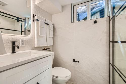 een witte badkamer met een toilet en een wastafel bij 411 S Owens St - Lakewood in Lakewood