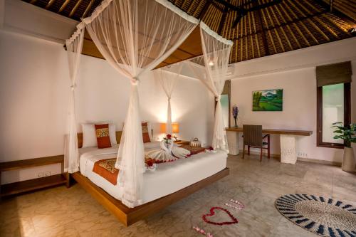 a bedroom with a bed with mosquito netting at Sayang Garden & Pool Vllla Ubud in Ubud