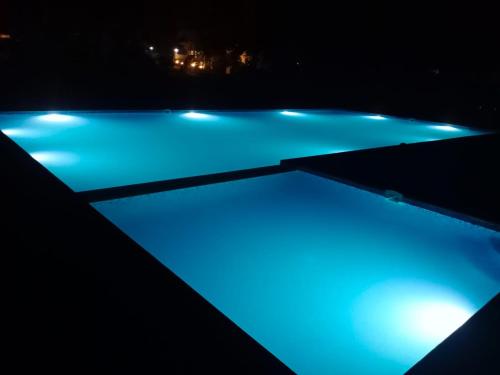 una piscina con iluminación azul por la noche en Van Vihar Resort, en Dhanwār