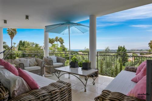 um pátio com 2 sofás e uma mesa com um guarda-chuva em Amazing Villa in Marbella! em Marbella