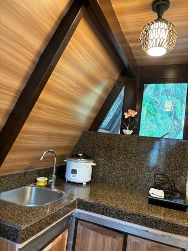 eine Küche mit einem Waschbecken und einem Fenster in der Unterkunft Kembali coast resort A-house style in Caliclic