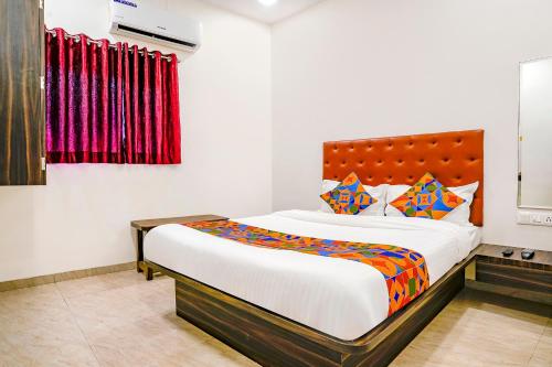 ein Schlafzimmer mit einem großen Bett mit bunten Kissen in der Unterkunft FabExpress Green View - Powai Lake in Mumbai
