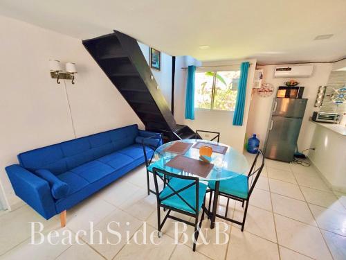 sala de estar con sofá azul y mesa de cristal en BeachSide B&B Hotel, en Arroyo Lucas