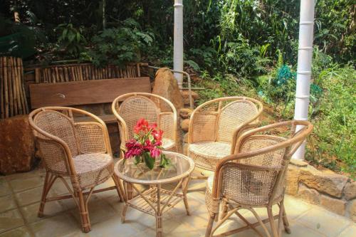 un gruppo di sedie e un tavolo con un vaso di fiori di Jungle Tide a Kandy