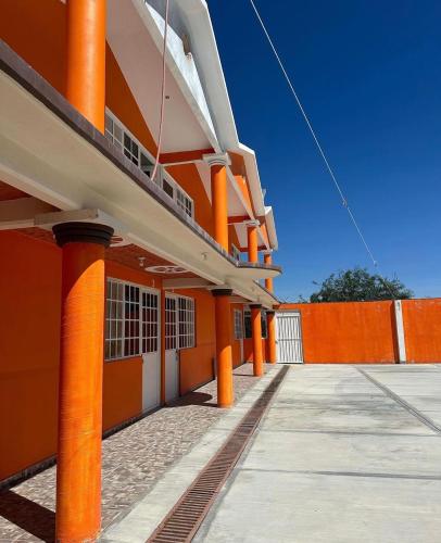 Cardonal的住宿－Hotel El Cubo，橙色的建筑,在它的侧面有橙色的柱子
