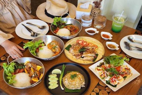 a table with many plates of food on it at Delio Boutique Hotel in Udon Thani