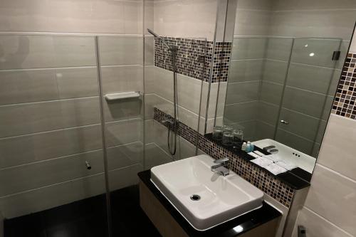a bathroom with a sink and a glass shower at Delio Boutique Hotel in Udon Thani