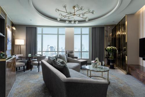 a living room with a couch and a chandelier at Centara Grand At CentralWorld in Bangkok