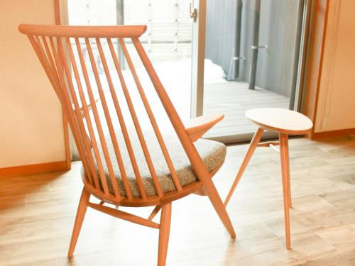 a wooden chair sitting in front of a door at Keiryuso Siorie in Matsumoto