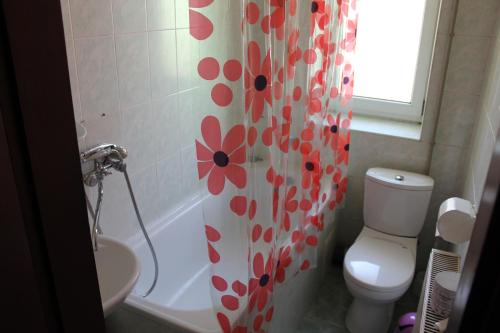 łazienka z toaletą i zasłoną prysznicową z kwiatami w obiekcie Zakarpattya w mieście Polyana (Polana)