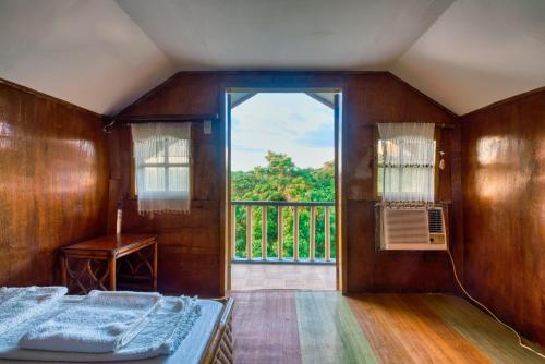 DaanbantayanにあるPilar Pilapil Beach Resortのベッドルーム1室(ベッド1台付)、バルコニー(窓付)