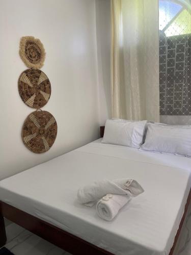 a white bed with a towel sitting on it at Nashu House Stone Town in Ngambo