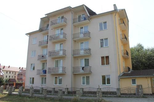 a tall white building with balconies on it at Zakarpattya in Polyana
