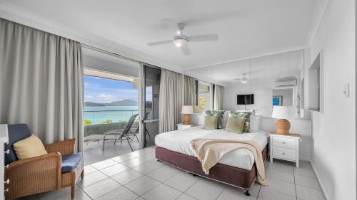 Schlafzimmer mit einem Bett und Meerblick in der Unterkunft Lagoon Beachfront Lodge 202 on Hamilton Island by HamoRent in Hamilton Island