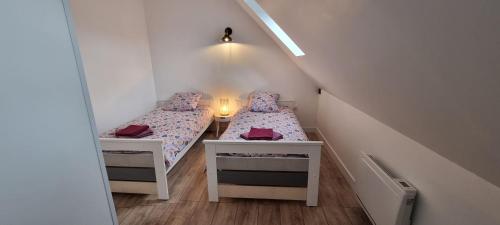 two twin beds in a room with a staircase at Aux Passagers de la Baie 3 in Le Crotoy