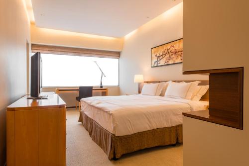 a hotel room with a bed and a television at Shanghai Centre Serviced Apartment in Shanghai