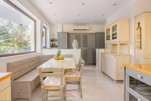 uma cozinha com mesa e cadeiras e uma janela em Villa Stefani with Private Pool em Atenas