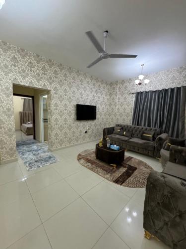 - un salon avec un canapé et une télévision dans l'établissement معبيله السابعه / خلف مدينه السلطان هيثم, à Ma‘ābīlah