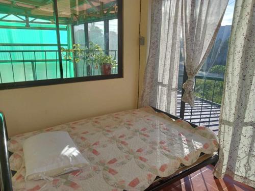 1 dormitorio con 1 cama y ventana con balcón en Villa Ceferina en Tagbilaran City