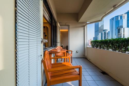 a balcony with two wooden chairs on a balcony at Shanghai Centre Serviced Apartment in Shanghai