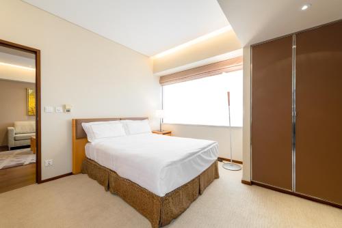a bedroom with a bed and a sliding glass door at Shanghai Centre Serviced Apartment in Shanghai