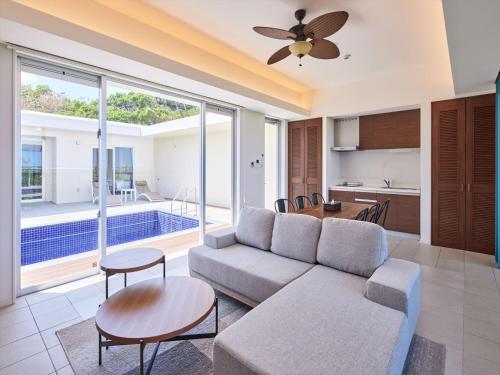 a living room with a couch and a table at The Pool & Sauna Villa MOTOBU in Motobu
