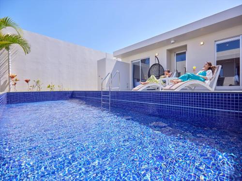 a swimming pool in front of a house at The Pool & Sauna Villa MOTOBU in Motobu