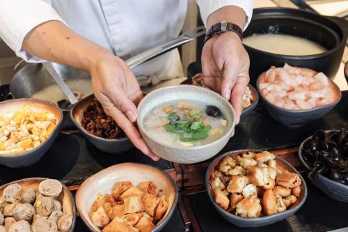 eine Person, die eine Schüssel Essen auf einem Herd hält in der Unterkunft Crowne Plaza Quanzhou Riverview, an IHG Hotel in Quanzhou