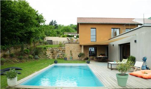 une piscine dans une cour à côté d'une maison dans l'établissement Villa avec piscine et vue admirable sur la nature, à Saint-Romain-au-Mont-dʼOr