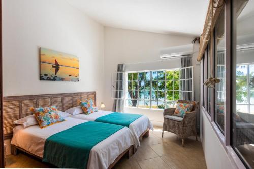 a bedroom with two beds and a window at Quaint 3 BDR Beach Bungalow in a fishing village in Grande Gaube